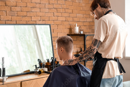 Male hairdresser trimming c...