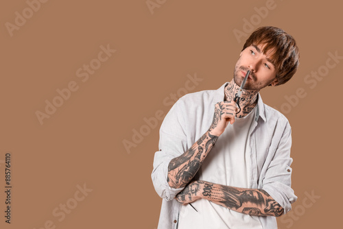 Thoughtful tattooed barber ...