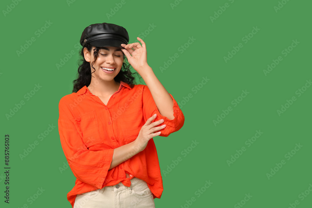 Stylish African-American woman in hat on green background Stylish African-American woman in hat on green background