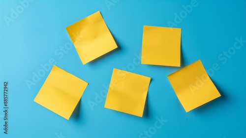 Five yellow sticky notes arranged on a bright blue background creating a vibrant contrast. photo