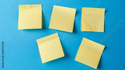 Five yellow sticky notes on a bright blue background, arranged in a row, ready for reminders or creativity.