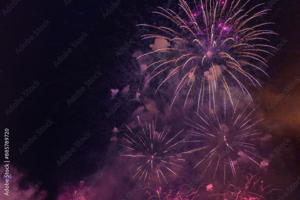 Purple fireworks with smoke over the black sky. Low key exposure.