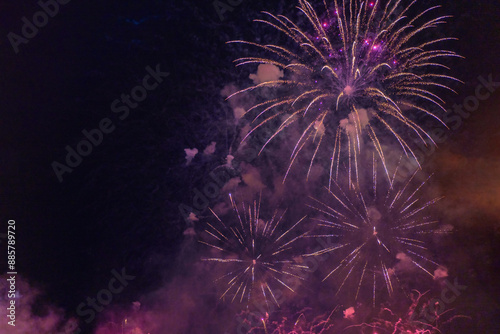 Obraz na płótnie Purple fireworks with smoke over the black sky. Low key exposure. w salonie