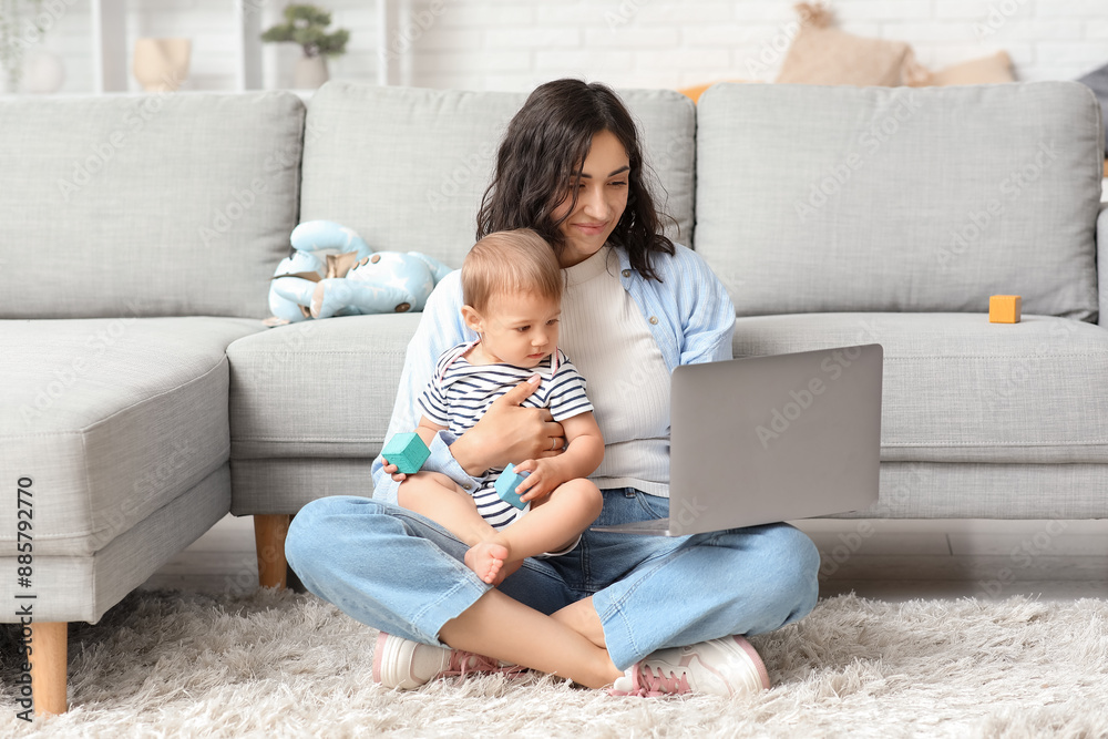 Cute baby and happy young mother working with laptop on maternity leave at home Cute baby and happy young mother working with laptop on maternity leave at home