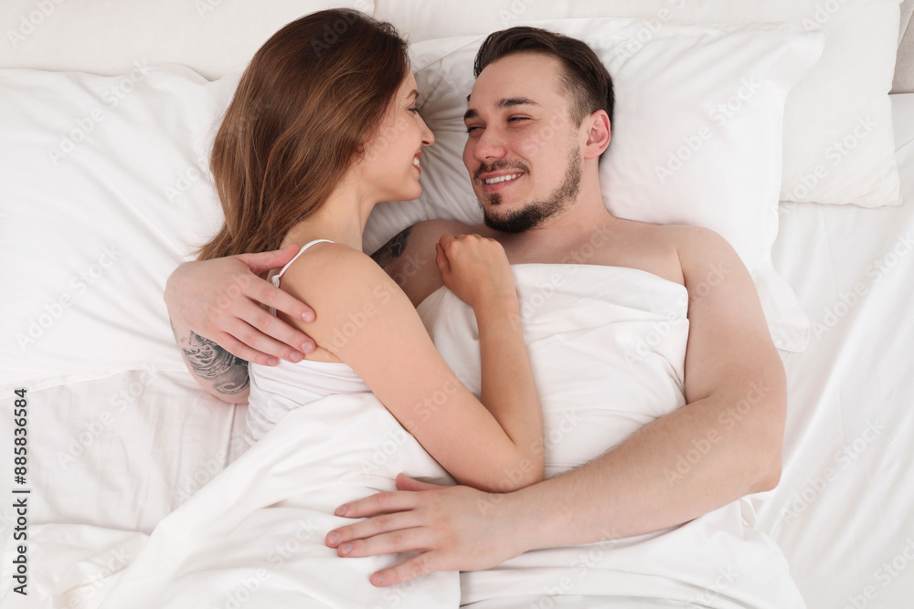 Lovely couple enjoying time together in bed at morning, top view Lovely couple enjoying time together in bed at morning, top view