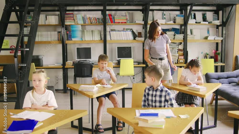 A teacher is providing help and guidance to young students in a classroom, creating an engaging academic environment for learning and development A teacher is providing help and guidance to young students in a classroom, creating an engaging academic environment for learning and development