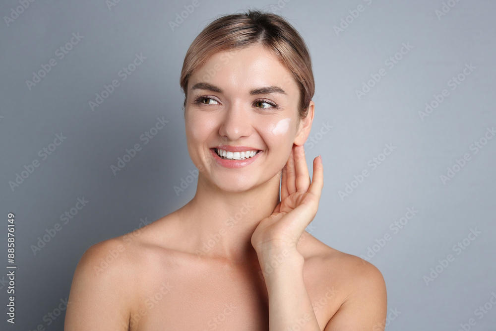 Beautiful woman with cream on her face against gray background Beautiful woman with cream on her face against gray background
