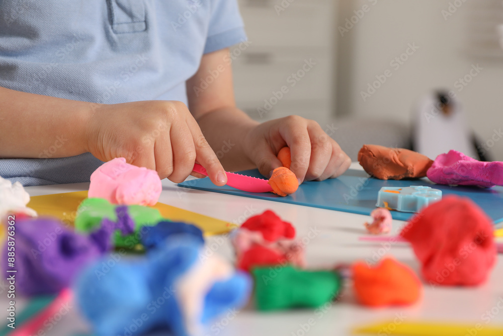 Little boy sculpting with play dough at table indoors, closeup Little boy sculpting with play dough at table indoors, closeup
