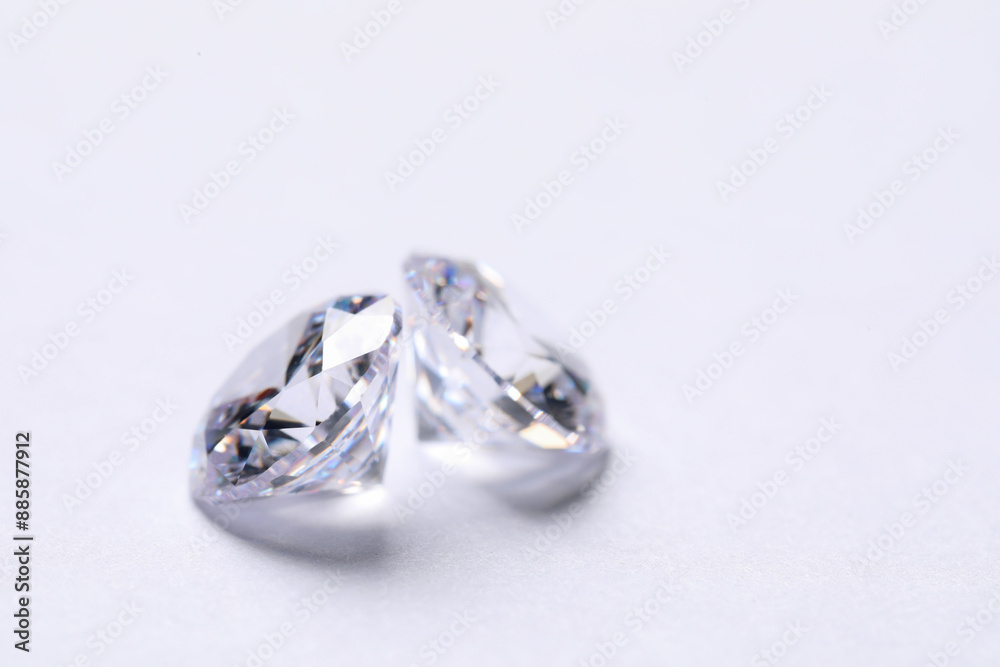 Two beautiful shiny diamonds on white background, closeup. Space for text Two beautiful shiny diamonds on white background, closeup. Space for text
