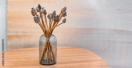 Obraz na płótnie Dried poppy flowers. Bouquet of dried flowers in a glass vase on a wooden table. Copy space w salonie