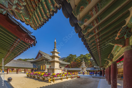 Gyeongju-si, Gyeongsangbuk-do, South Korea - November 14, 2017: Morning view of Dancheong on the eaves of Buddhist sanctuary against Dabotap Tower at Bulguksa Temple
 photo