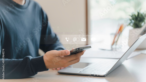 Obraz na płótnie Businessman using a smartphone and touching on virtual screen contact icons, Contact us or Customer support hotline people connect, symbol telephone, mail, address and mobile phone. w salonie