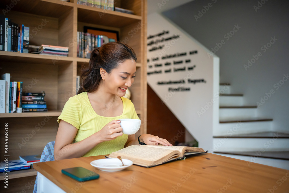 Young woman reading book and drink hot coffee in library at home, smiling, laughing, enjoying bookworms hobby, home leisure time Young woman reading book and drink hot coffee in library at home, smiling, laughing, enjoying bookworms hobby, home leisure time
