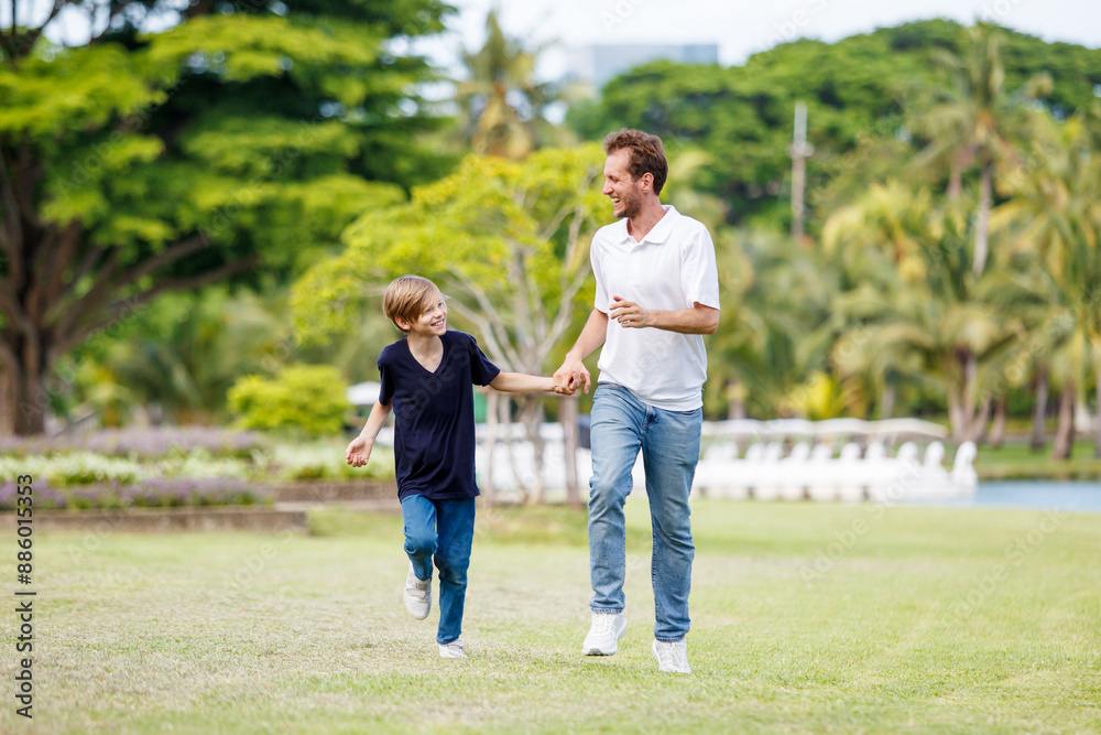 Man piggyback his son on a shoulder and walking around the park. Man piggyback his son on a shoulder and walking around the park.