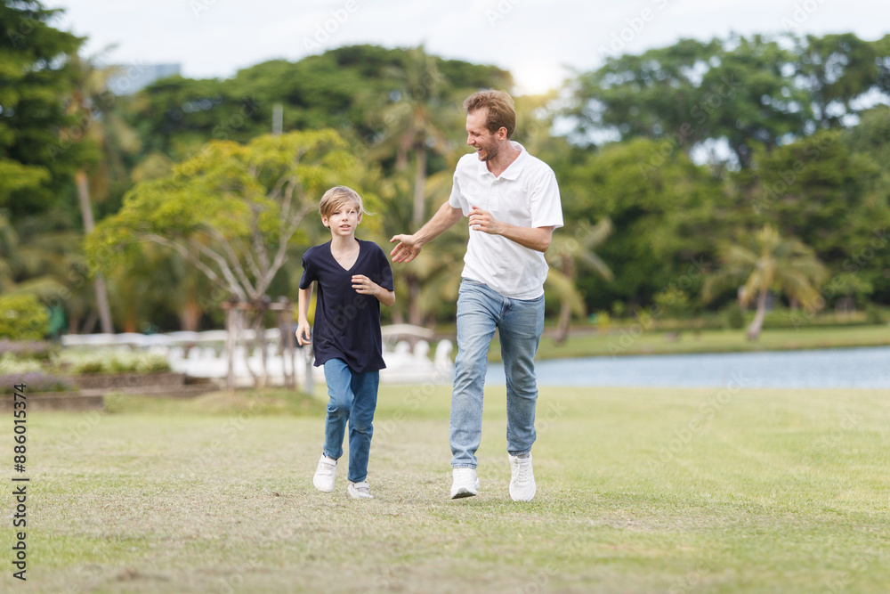 Man piggyback his son on a shoulder and walking around the park. Man piggyback his son on a shoulder and walking around the park.