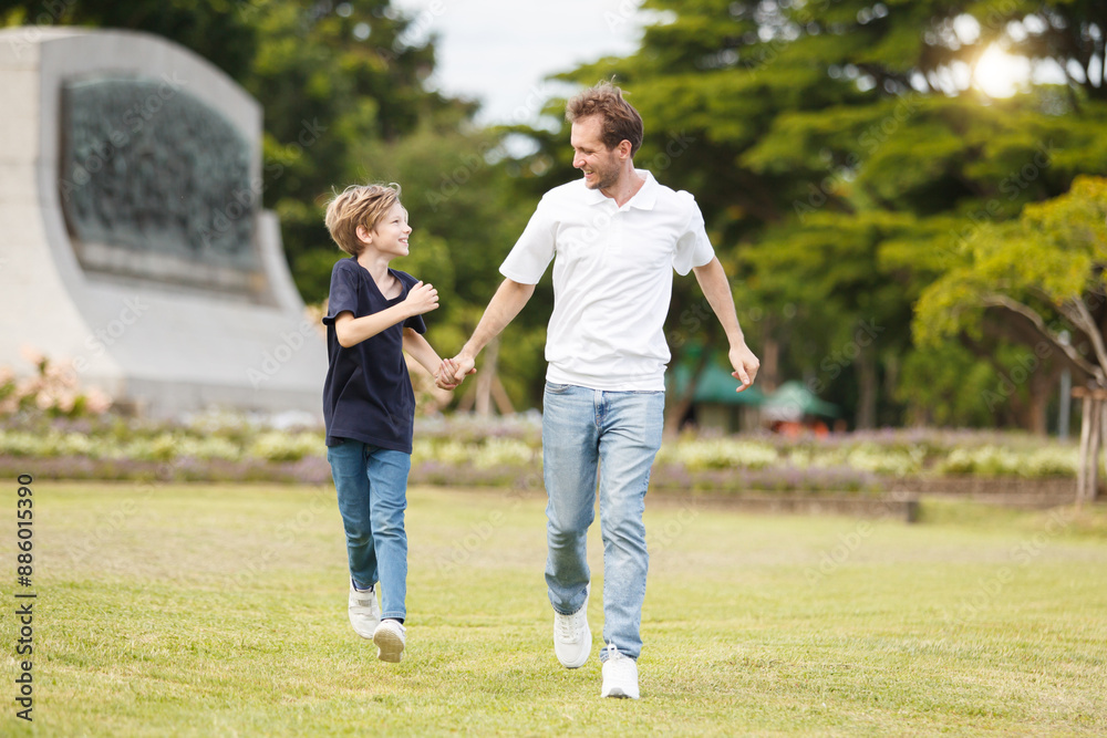 Man piggyback his son on a shoulder and walking around the park. Man piggyback his son on a shoulder and walking around the park.
