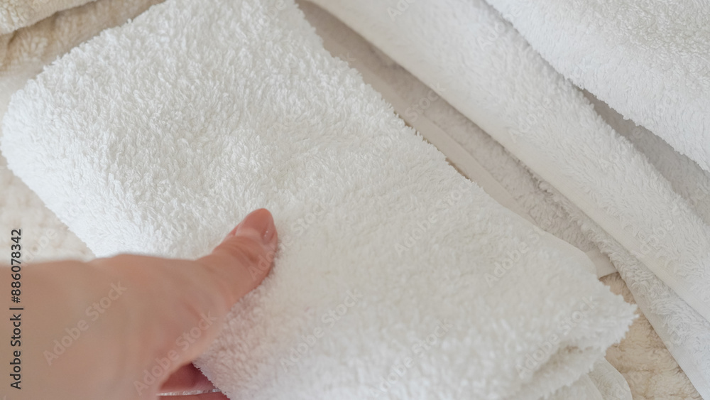 White and beige towels neatly stacked, adding a touch of elegance and comfort. White and beige towels neatly stacked, adding a touch of elegance and comfort.