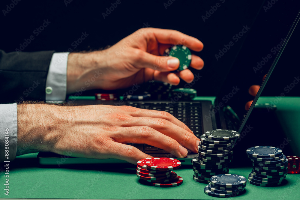 Person Playing Online Poker Game With Laptop and Chips Person Playing Online Poker Game With Laptop and Chips