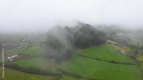 Drone shot of rural area of Barrio Güitig at the foot of Rumiñahui volcano, Machachi, Mejía Parish, Pichincha, Ecuador. Landscape of patches of fields with dark and dense clouds above the Village