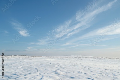 a snow covered field with a blue sky in the background