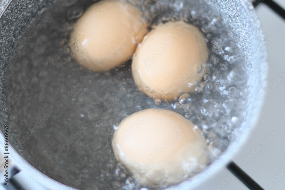 Three eggs in a pot of boiling water, a common cooking scene.