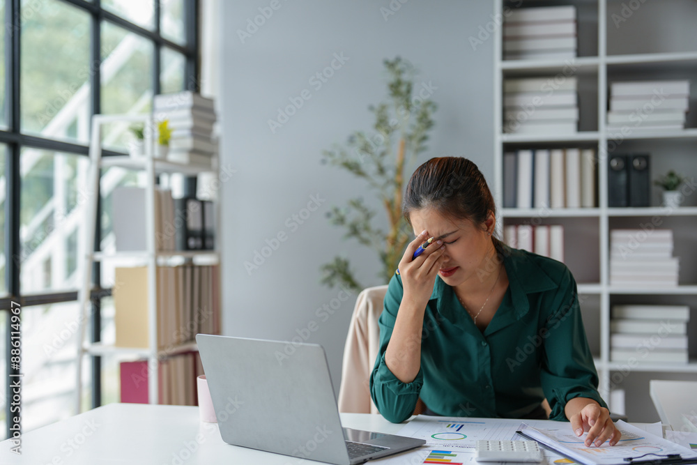 Asian businesswoman who is tired and sleepy from sitting at a desk for a long time. Works in financial documents, accounting, statistics and has office syndrome. Asian businesswoman who is tired and sleepy from sitting at a desk for a long time. Works in financial documents, accounting, statistics and has office syndrome.
