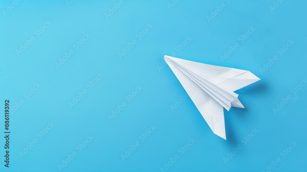 White paper airplane on a vibrant blue background, symbolizing creativity, freedom, and innovation. Minimalist design with copy space. White paper airplane on a vibrant blue background, symbolizing creativity, freedom, and innovation. Minimalist design with copy space.