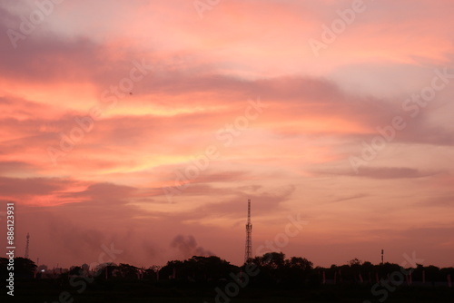 Beautiful orange sky, Golden Sky, with clouds sunset and in Evening gold Sky Hour with Romantic Orange. Nature sky sunset background with factory smoke.