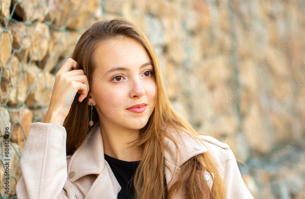 Young smiling girl, portrait against the background of a stone wall. Fashion style trend. Young smiling girl, portrait against the background of a stone wall. Fashion style trend.