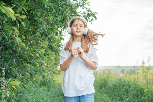 A child with headphones listening to music and dancing