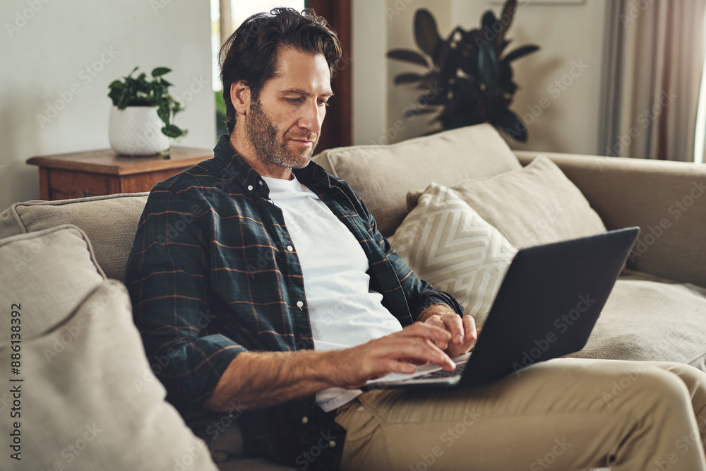 Man, home and couch with laptop for remote work as freelance writer and journalist for newspaper. Male person, editor and sofa in living room for online research on website for headline story Man, home and couch with laptop for remote work as freelance writer and journalist for newspaper. Male person, editor and sofa in living room for online research on website for headline story
