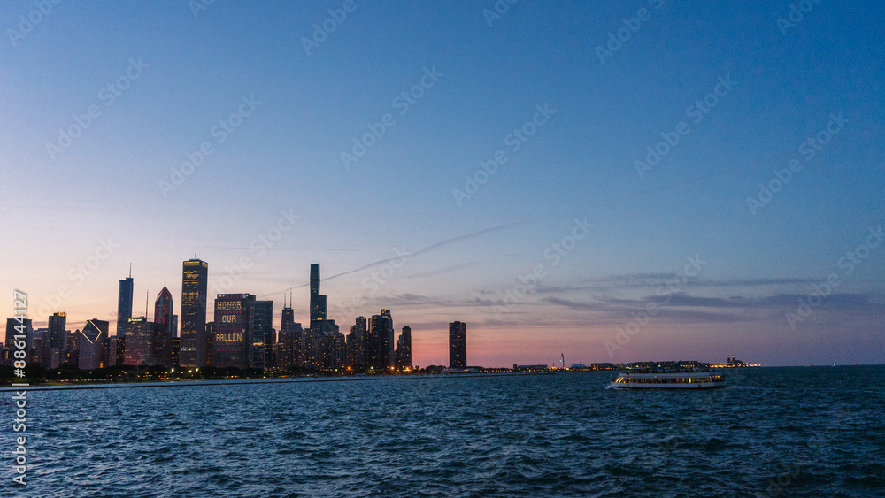 Naklejka premium Downtown Chicago cityscape at sunset from across the bay, above the water. 