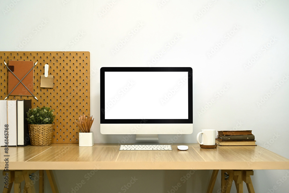 Stylish workplace. Modern desktop computer, books and houseplant on white table Stylish workplace. Modern desktop computer, books and houseplant on white table