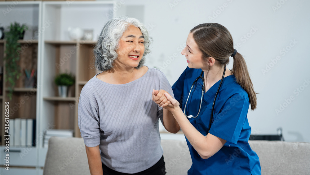 Obraz premium young caregiver assists her elderly woman patient at a nursing home. senior woman is assisted by a nurse at home.