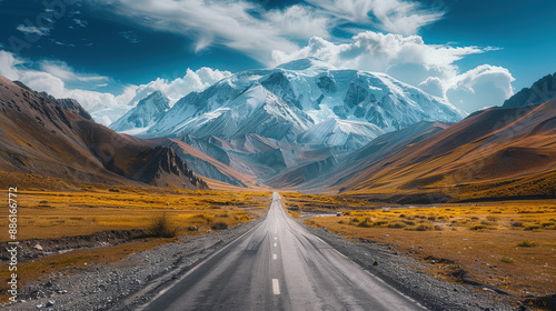 An empty asphalt highway winds through a scenic desert mountain landscape under a bright blue sky