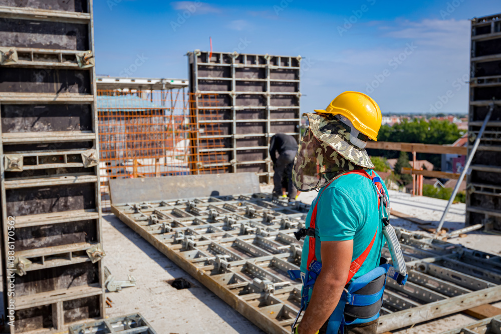 View on building site as riggers, workers are assembly wooden demountable mold View on building site as riggers, workers are assembly wooden demountable mold