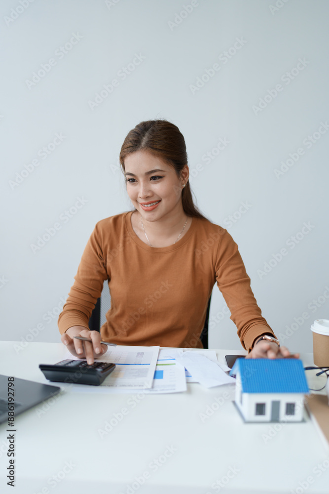 Smart Mortgage Planning woman using a calculator to make Calculations and Consideration Smart Mortgage Planning woman using a calculator to make Calculations and Consideration
