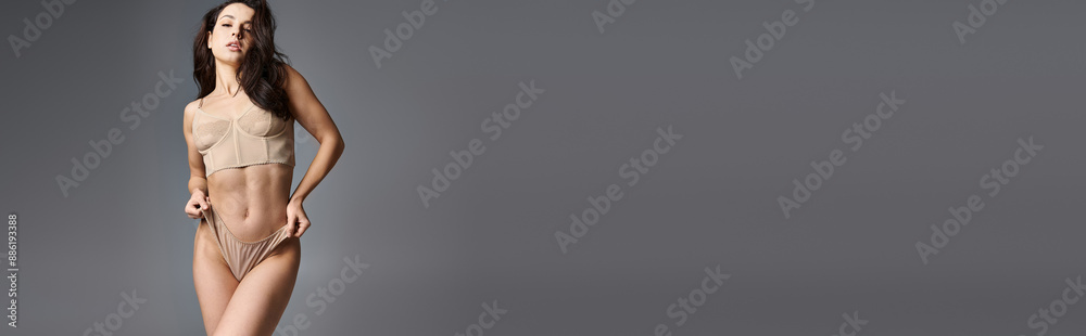 Young woman seductively posing in tan bra. Young woman seductively posing in tan bra.