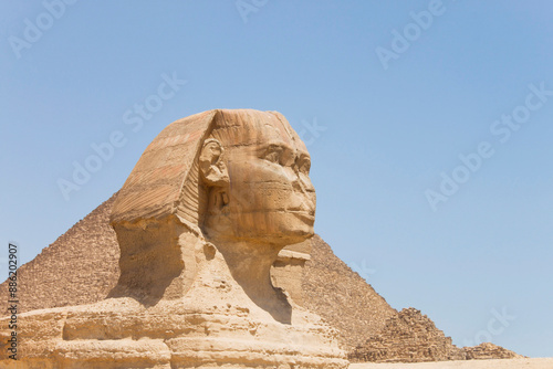 Great Sphinx against pyramides and blue sky, Giza, Egypt