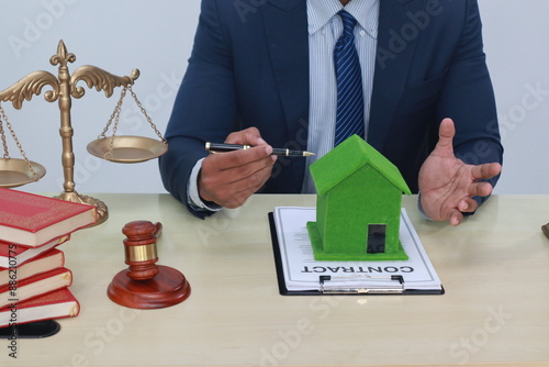 A businessman in a suit sits at a table discussing the Clean Energy Act, which incentivizes renewable energy adoption, clean raw material use in energy production, and energy-efficient transportation. photo