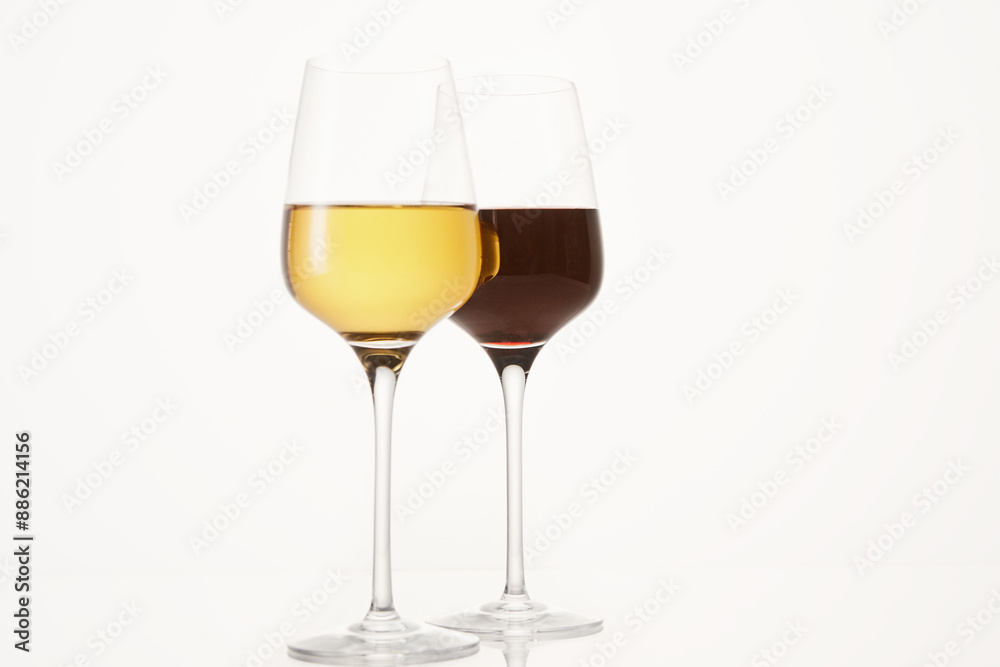 Two wineglasses half filled with red and white wine. Two wineglasses half filled with red and white wine.