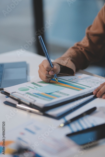 Business woman accountant working audit and calculating expense financial annual financial report balance sheet statement, doing finance making notes on paper checking document.