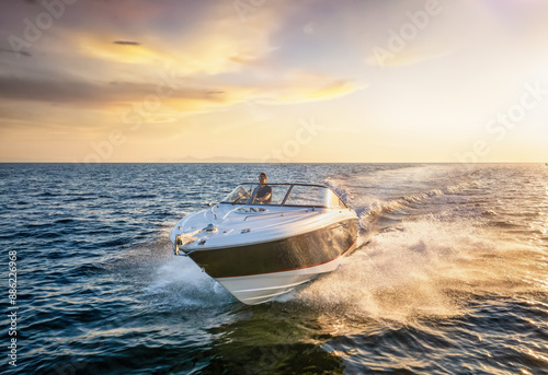 Obraz na płótnie Front view of a sports motor boat cruising with high speed over the blue sea during summer sunset time w salonie