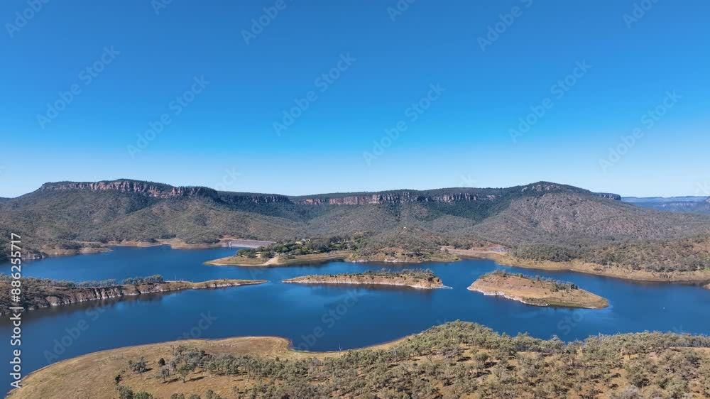 Aerial captures the complex geography of Cania Dam wall, Cania Lake, headlands into the waters and small isles off the National Park recreation area. Above the area is the table form Castle Mountain. Aerial captures the complex geography of Cania Dam wall, Cania Lake, headlands into the waters and small isles off the National Park recreation area. Above the area is the table form Castle Mountain.