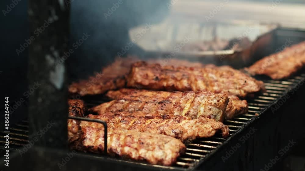 close up grilling pork ribs on barbecue grill outdoors summer. Preparing juicy pork meat on coal in smoke. BBQ. Picnic time with Grill outdoors party. 4k. close up grilling pork ribs on barbecue grill outdoors summer. Preparing juicy pork meat on coal in smoke. BBQ. Picnic time with Grill outdoors party. 4k.