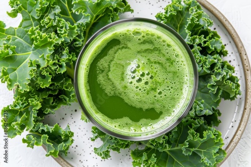 Desintoxication mixture of green col rizada juice with fresh col rizada leaves on a white plate over a white background photo