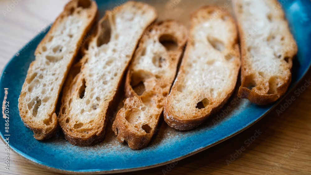 A close-up of crispy, golden-brown baguette slices, showcasing their texture and holes. The image highlights the crunchiness and detail, ideal for culinary, bakery, or food-related content. A close-up of crispy, golden-brown baguette slices, showcasing their texture and holes. The image highlights the crunchiness and detail, ideal for culinary, bakery, or food-related content.