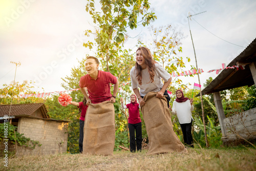 A group of people are playing a game of sack race