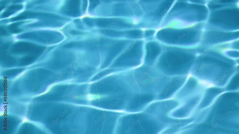 Blue water in the swimming pool with sunlight reflections. Abstract background