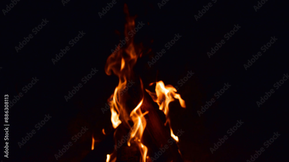 firewood burns, fire coals at night. Red hot coals glowing on a dying campfire pit. Orange glow from the coals at the stake at night. flames on a black background firewood burns, fire coals at night. Red hot coals glowing on a dying campfire pit. Orange glow from the coals at the stake at night. flames on a black background